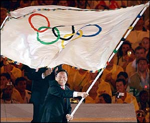 Beijing mayor Wang Qishan takes the Olympic flag