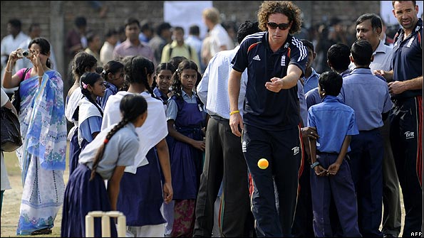 Ryan Sidebottom throws a ball to a girl during the visit to the school. (Pic: AFP)