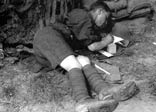 A soldier in a trench, writing his diary