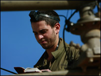 Soldado israelense ora em seu tanque pertencente a unidade perto da passagem de Sufa, no sul de Israel