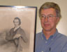 Keith Rattenbury standing next to the portrait of his great (x3) grandfather, the Reverend John Rattenbury