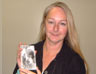 Christine Finn holding a photograph of herself when three years old, with her mother and a family friend, outside Jersey's German underground hospital