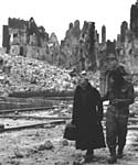 British soldier and French civilian pick their way through what remains of Caen, July 1944