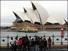 Tourists look at the Opera House in Sydney