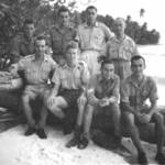 Mr. George Thompson, seated 1st left on the beach of Cocos Keeling Island, 1945.