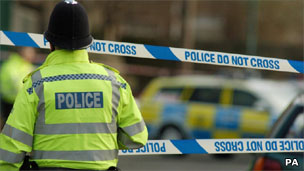 Policeman standing by police cordon tape