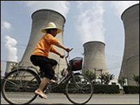 Cyclist in front of power station in China