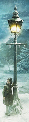 Lucy Pevensie (Georgie Henley) by the lamppost in a snowy wood.