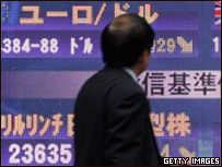 Japonês passa em frente a painel de cotações em Tóquio