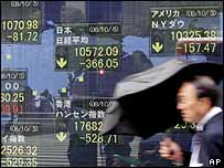 Homem passa diante de indicadores do Nikkei (AP)